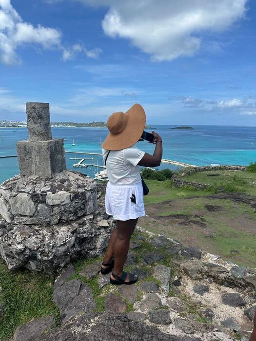Traveler photographing sweeping views from historic ruins