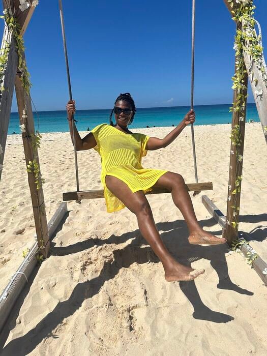 Traveler on a beach swing in a yellow dress
