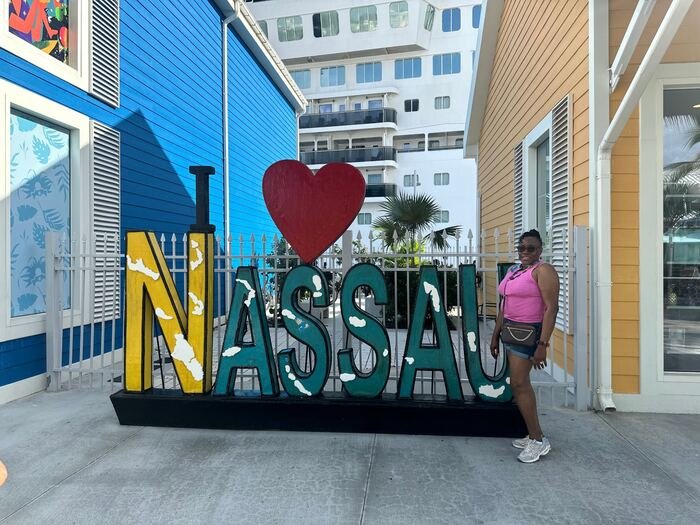 Traveler posing by the I Love Nassau sign